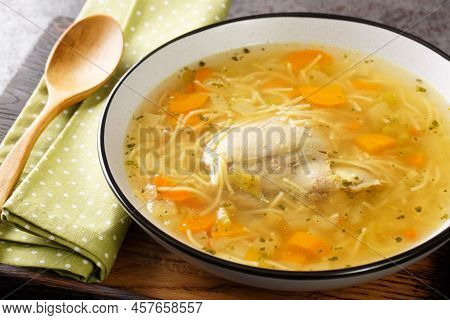 Dietary Chicken Soup With Vermicelli And Vegetables Close-up In A Bowl On A Wooden Tray On The Table