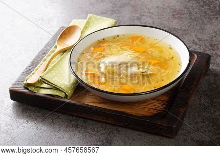 Delicious Homemade Chicken Broth With Noodles And Vegetables Close-up In A Plate On A Wooden Tray. H