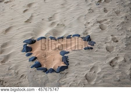 On A Beach A Heart Was Formed From Individual Stones. Stone Heart On The Beach.
