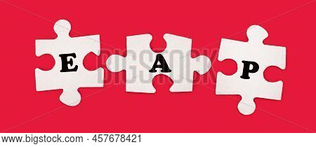 Three White Jigsaw Puzzles With The Text Eap Employee Assistance Program On A Bright Red Background.