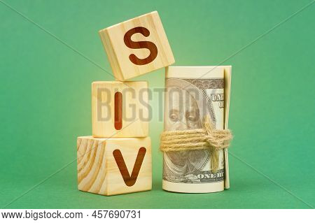 Business Concept. On A Green Surface, Dollars And Cubes With The Inscription - Siv