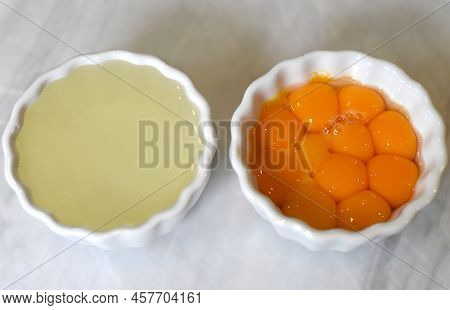 Separeted Yolk And Eggwhites In Bowls On A Table
