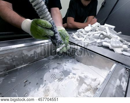 A Man Working With A Working Vacuum Cleaner To Clean The White Powder Of Polyamide From A Model Prin