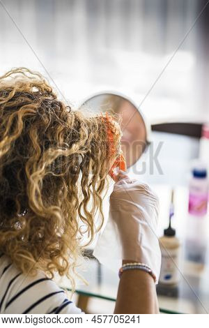 Unrecognizable Female Work On Her Long Blonde Hair With Dye To Color And Make Younger - People With 