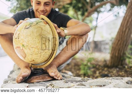 Future Of The World With Young Caucasian Teenager Loking A Globe Earth - People And Travel Lifestyle