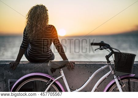 People Enjoying Outdoor Leisure Actvity Looking A Beautiful Coloured Sunset - Woman With Long Curly 