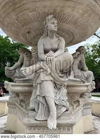 Statue Of A Seated Woman With A Wreath On Her Head At The Danubius Fountain. Budapest, Hungary