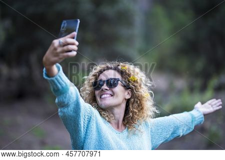 Happy Adult Caucasian Woman Enjoying The Phone To Take Picture To Share On Social Media - Outdoor Le