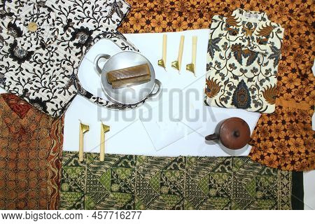 Flat Lay Batik Clotes With Canting, Small Pan And Wax Earthenware Glass Isolated On White Background