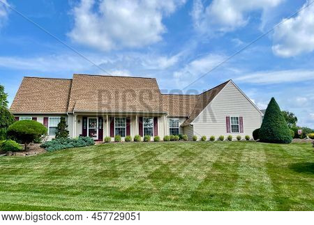 Lancaster, Pennsylvania - July 6, 2022: A Nicely Striped Mown Green Lawn With A House In The Backgro