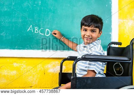 Young Teenger School Kid With Disability On Wheel Chair Writing On Board While Looking At Camera - C