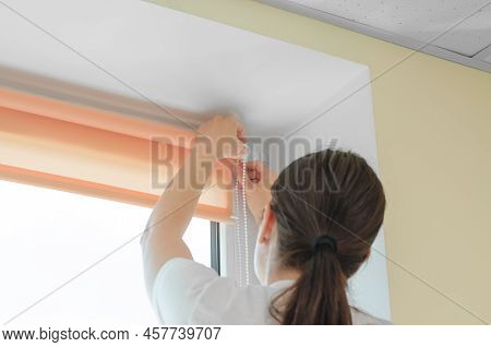 Female Hands Installing Roller Blinds On The Window. Installation Of Roller Blinds