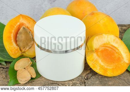 White Jar Of Mok-up Skin Moisturizer And Fresh Apricots. Skin Care Concept. Apricot Moisturizer