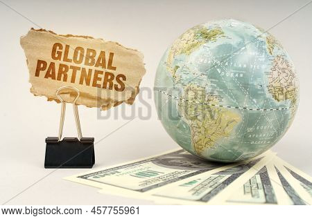 Business Concept. On A Gray Surface, A Globe, Dollars And A Cardboard Plate With The Inscription - G