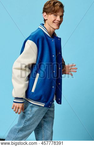 Handsome Attractive Cute Guy Student In A Trendy Blue Jacket Dynamically Posing On A Light Blue Back