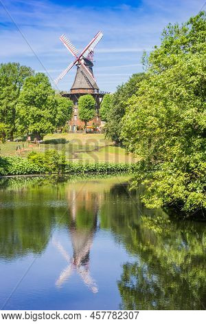 Historic Windmill With Reflection In The Canal Of Bremen, Germany