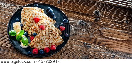 A Plate Of Pancakes With Cheese And Fruits