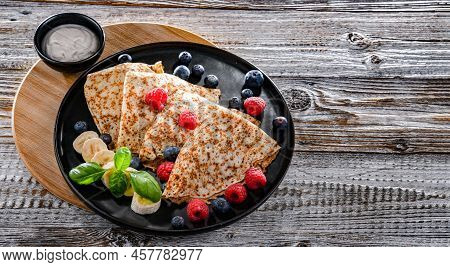 A Plate Of Pancakes With Cheese And Fruits