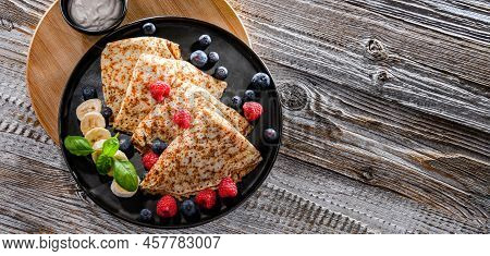 A Plate Of Pancakes With Cheese And Fruits