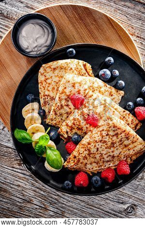 A Plate Of Pancakes With Cheese And Fruits