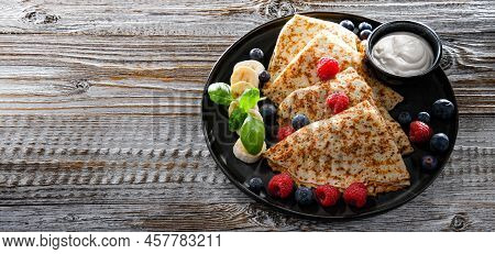 A Plate Of Pancakes With Cheese And Fruits