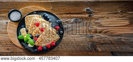 A Plate Of Pancakes With Cheese And Fruits