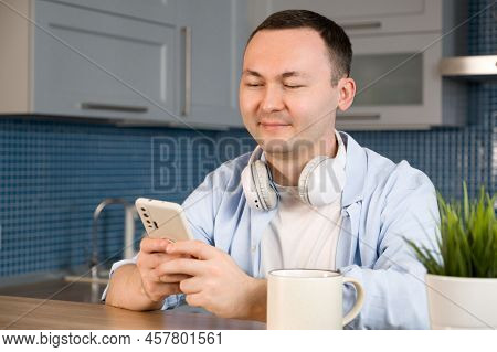 Happy Smiling Asiam Man Using Smartphone For Online Shopping Or Communication,answering Mail Etc.