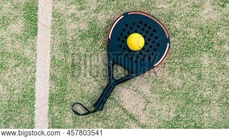 Yellow Ball On Top Of The Padel Racket And Behind Net On Green Court Grass Turf