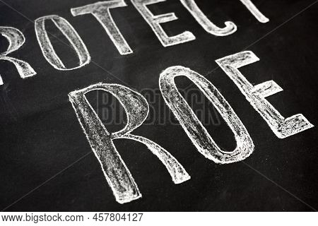 A Sign That Says Protect Roe. Demonstrators Poster. Women And Their Rights