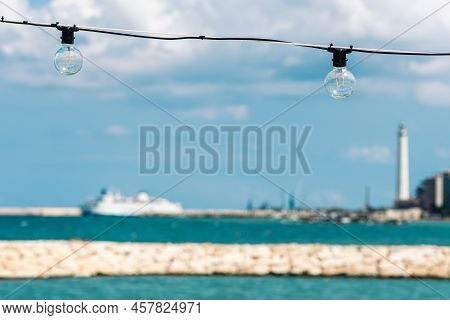 Vintage Light Bulbs With Blue Sky, White Clouds, Blue Sea And Breakwater, Bari Port Or Harbor With S