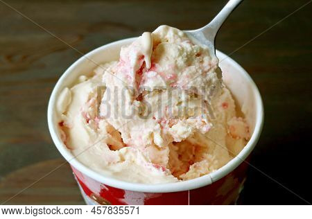 Closeup Of Spoon Scooping Mouthwatering Creamy Strawberry Cheesecake Ice Cream
