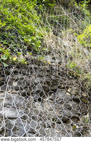A Protective Metal Mesh Covers The Rocks From Rockfall. Metallic Net Protects The Road From Landslid