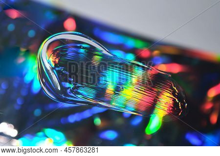 Drop Of Cosmetic Transparent Gel On A Halographic Background. The Texture Of The Serum, Heir Gel Or 