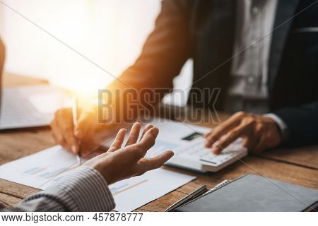 Two Businessmen Are Reviewing Monthly Sales Documents For Analysis And Marketing Plans For More Sale