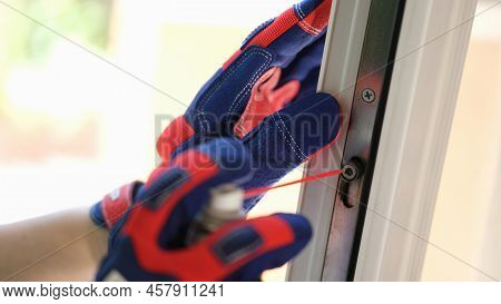 Close-up Of Repairman Using Lubricate For Fix Up Problem With Lock Of Plastic Window. Maintenance Ch