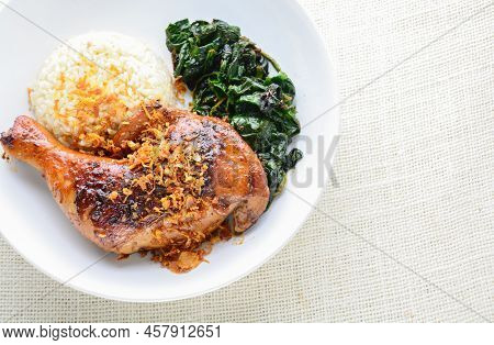 Chicken Drumstick Marinated With Spicy Chilli Sauce And Herbs, Served With Cooked Rice And Spinash.