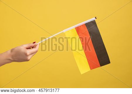 Profile Side View Closeup Of Woman Hand Holding Germany Flag. Day Of Germany - 3th October. Indoor S