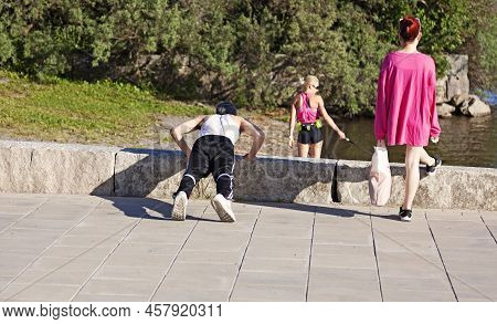 Vaasa, Finland - June 21, 2022: Exerciser Doing Push-ups On The Beach Promenade