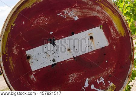 Weathered, Scratched And Dirty Old Red And White Round No Entry Road Sign With Muddy Road Leading