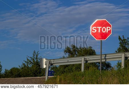 Red Stop Sign With Blue Sky And Clouds Background Of The Road