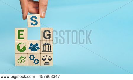 Esg Concept Of Environmental, Social And Governance. Words Esg On A Wood Cubes. Hand Holds Wooden Cu