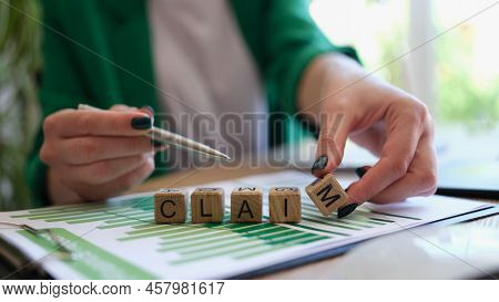 Close-up Of Woman Pointing With Pen On Word Claim And Putting Wooden Cube. Business Conflict With Pa