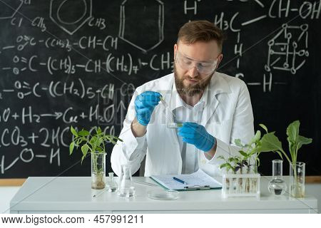 A Biotechnologist In A Modern Laboratory Conducts Experiments With Synthesizing Compounds Using Drop