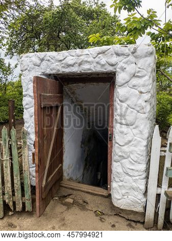Open Door Historic Vintage Root Cellar Dug Underground In The Countryside Near The Trees