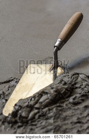 trowel with wet concrete