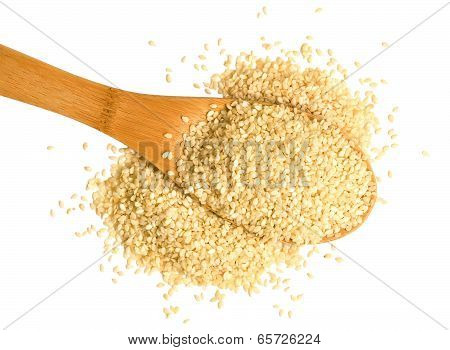Big scoop of sesame seeds over a white background.