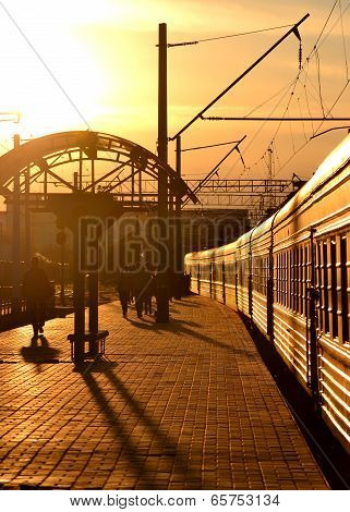 Train Leaving The Railway Station At Sunset