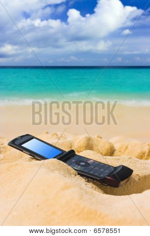 Telefono cellulare sulla spiaggia di sabbia