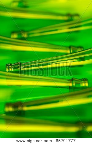 Eight Green Beer Bottles Lying Horizontally. Shot With Yellow Light