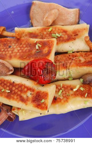 russian food - meat wrapped in a pancake with red hot pepper  and pickled mushrooms served on blue plate isolated over white background high resolution hidef